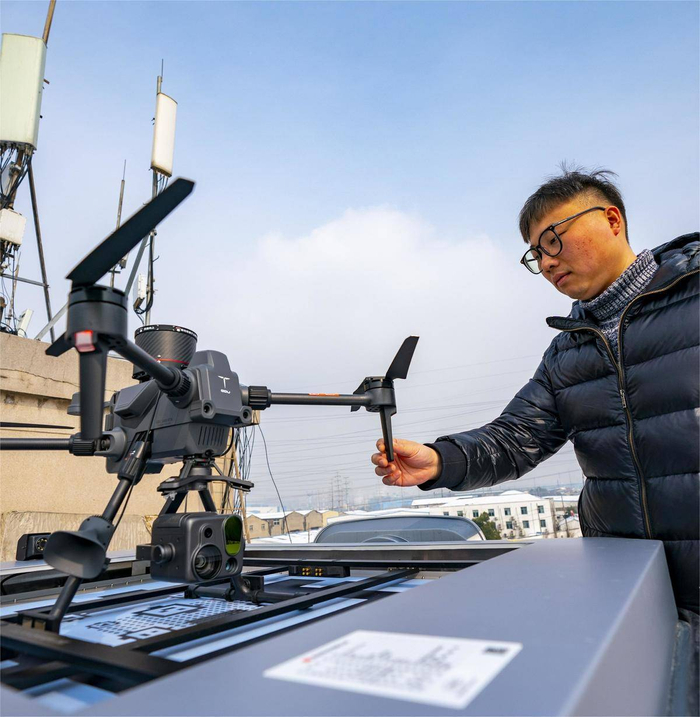 图为无人机保障小分队工作人员检查返航的无人机。（湖北日报全媒记者 魏铼 通讯员 范义虎 汤志坚 摄）