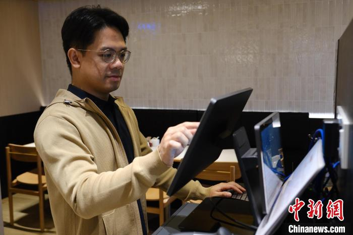 潘家杰在操作收银系统。记者 蔡敏婕 摄