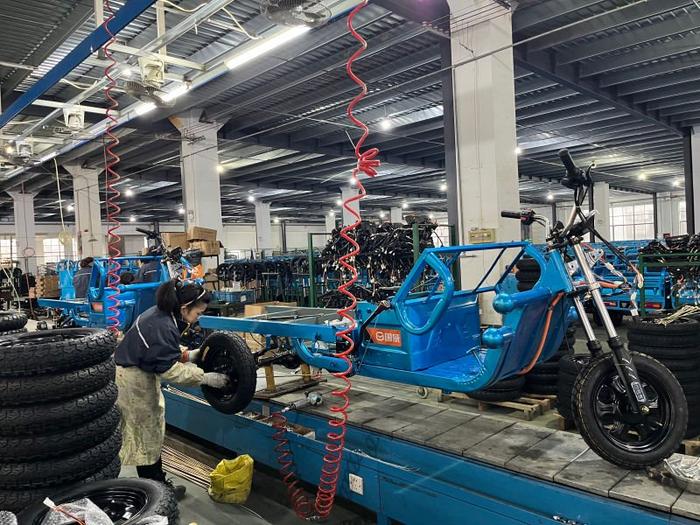 在无锡锡山区的江苏国威摩托车有限公司厂房内，工人正在装配电动三轮车。（受访者供图）