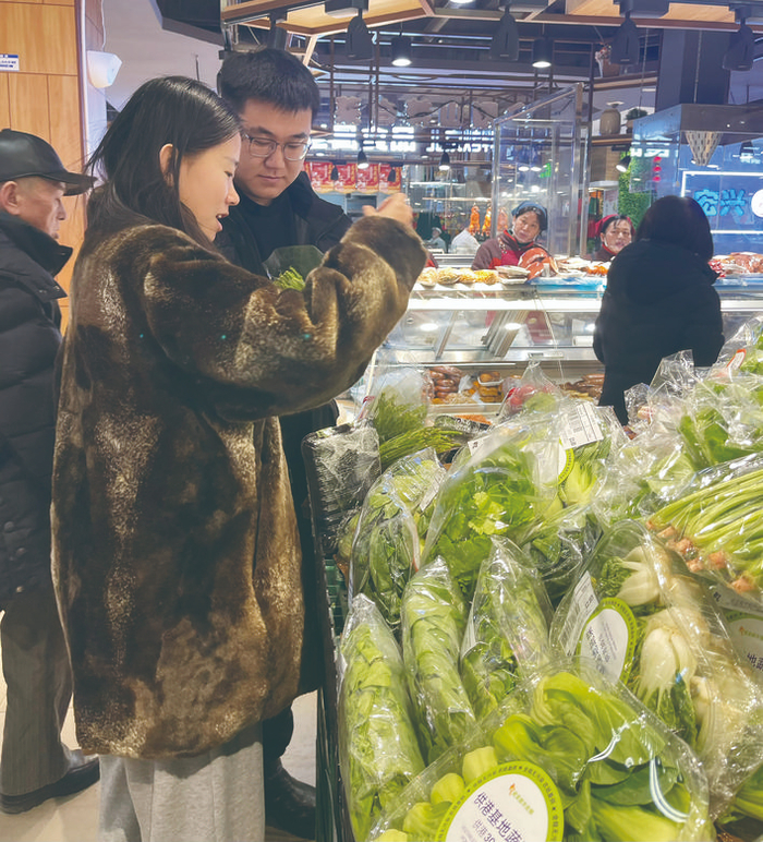 消费者在超市仔细挑选无公害蔬菜。 李依南 摄