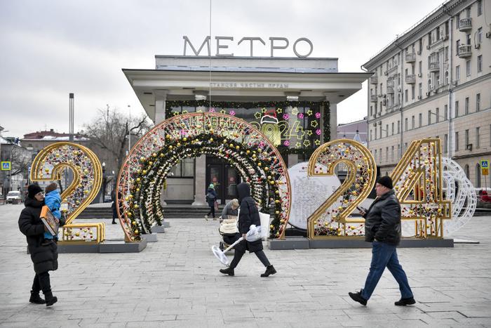   2023年12月22日，在俄罗斯首都莫斯科，人们从新年装饰前走过。新华社发（亚历山大摄）