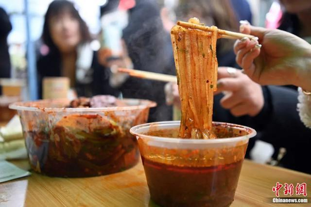 3月14日，甘肃天水，游客正在品尝麻辣烫。劲道爽滑的粉条是食客们最为推荐的。九美旦增 摄