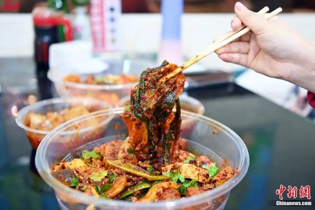 3月14日，甘肃天水，游客品尝麻辣烫。近日，甘肃天水麻辣烫在网络平台火爆，吸引全国各地众多游客前来品尝。九美旦增 摄
