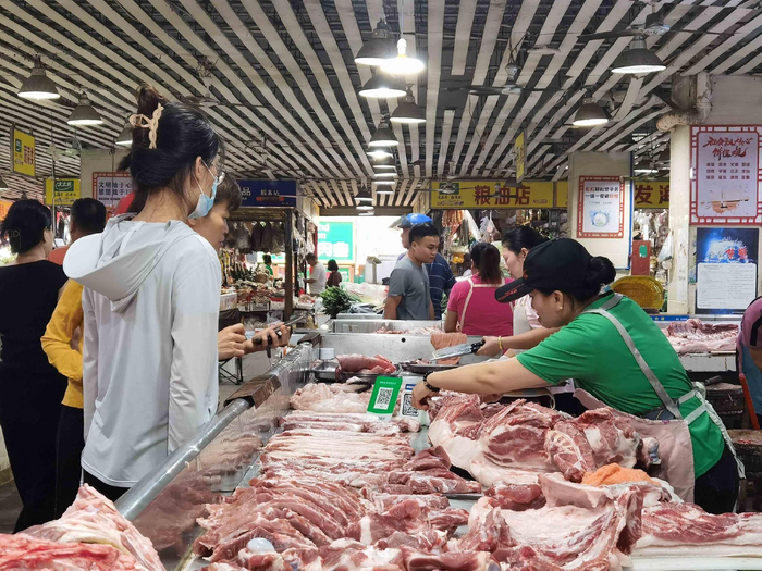 市民在农贸市场摊位前选购猪肉。记者 蒙健 摄