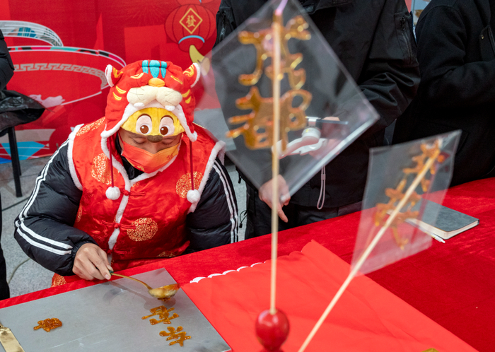 ▲春运期间，成都东站汽车客运站为旅客送糖画 摄影：陶轲