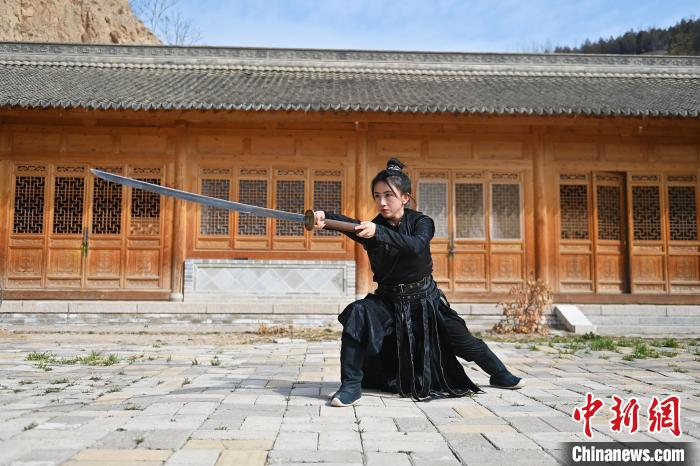 图为张含亮在天水古民居前展示苗刀。李亚龙 摄