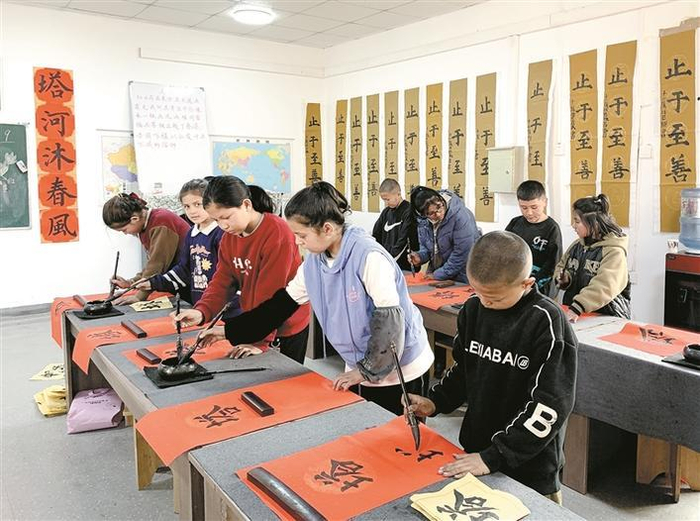     新疆唐锦纺织有限公司开办的“唐锦书院”内，孩子们在练习毛笔书法（资料图片）。    兵团日报全媒体记者  常丫丫  摄