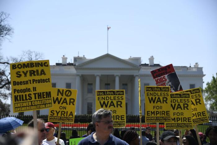   2018年4月14日，在美国华盛顿白宫北侧，人们手持标语抗议对叙利亚进行军事打击。新华社记者杨承霖摄