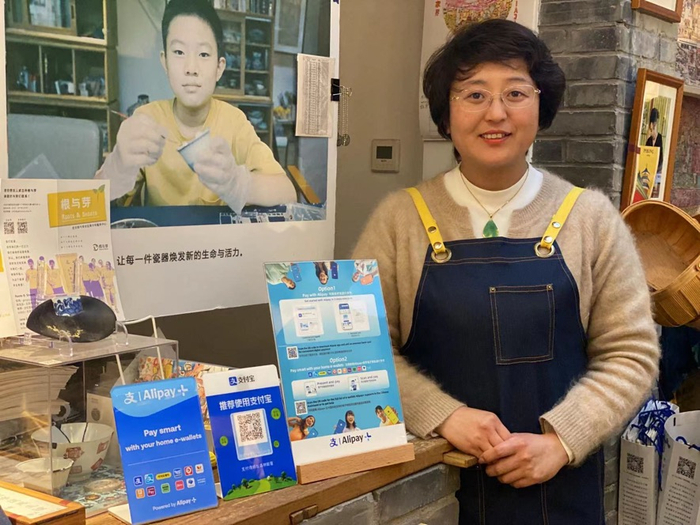 （图 | 文化艺术工作坊“乾坤空间”负责人王京的店里支持多种支付方式，方便外国友人）