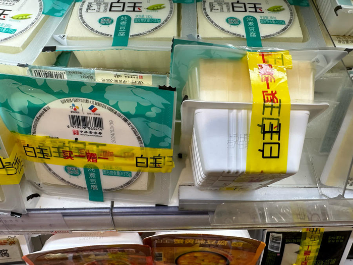 两盒豆腐捆绑销售，不透明胶带正好把下面一盒豆腐包装上的生产日期遮挡住了。