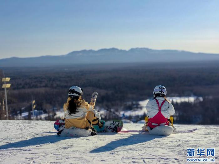 2月2日，雪友在长白山和平滑雪场的雪坡上远眺长白山主峰。新华社记者 王帆 摄