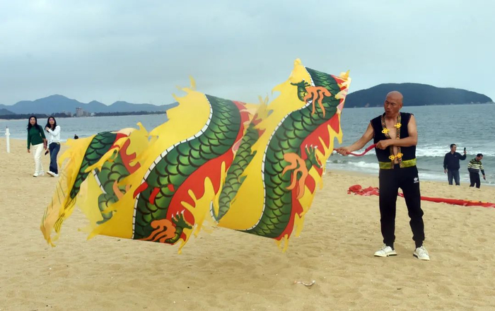 来自重庆的“候鸟”在沙滩舞龙。刘再扬 摄