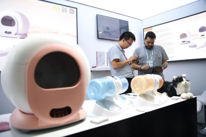 一家智能猫砂盆产品展台，外国采购商在了解信息。邓华摄（新华社）
