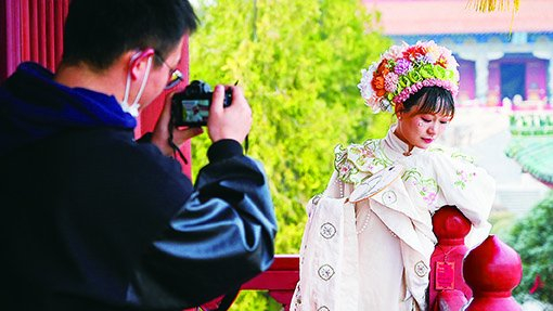 　　▲两名游客在许昌春秋楼景区拍照（3 月 5 日摄）。