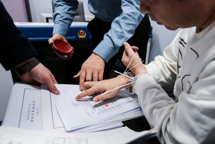 3月14日8时11分，北京首都国际机场三号航站楼，孙大龙在讯问笔录上按指印。