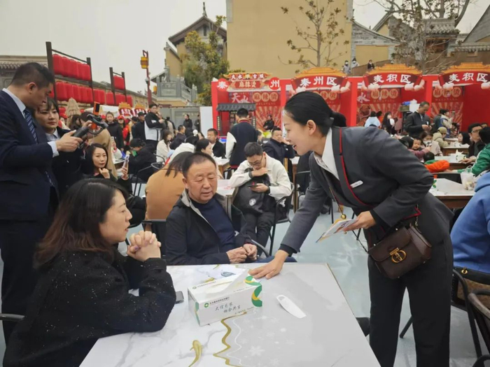 天水秦州农村合作银行在天水麻辣烫吃货节现场为等候的食客介绍金融便民工具及政策。图片由人民银行天水市分行提供