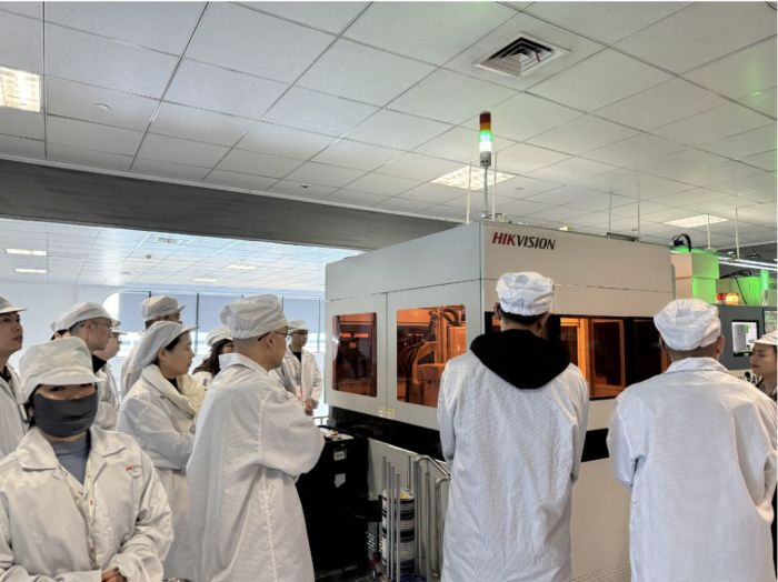 ▲与会企业代表观摩海康威视产线自动化设备实际应用情况