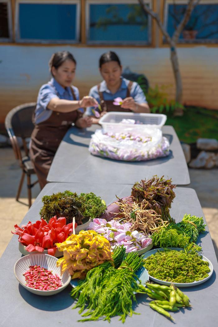 云南省红河哈尼族彝族自治州开远市一家餐馆里，服务员分拣早市买来的鲜花野菜（3月18日摄）。 新华社发（陶家淇 摄）