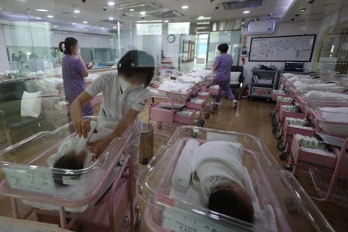 ▲韩国首尔的产后护理中心，护士们正在照顾婴儿