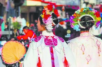     头戴簪花的游客在福建省泉州市蟳埔村游览。▲ 新华社记者 魏培全/摄