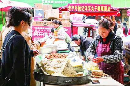 　　3月19日，游客在天水市秦州区的一摊位前购买特色小吃。新华每日电讯记者 马希平 摄