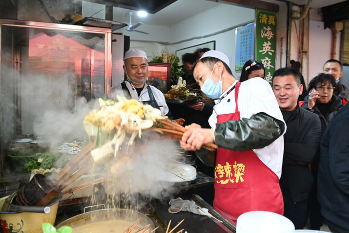2024年3月16日，在天水市秦州区的天水名优小吃城一麻辣烫店，商家为游客加工麻辣烫。新华社记者 范培珅 摄