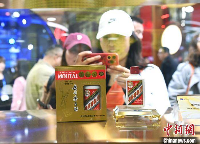 3月20日，第110届全国糖酒会在成都开幕，图为观众在贵州茅台展台参观打卡。　安源 摄