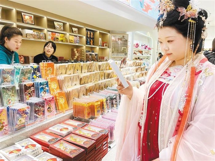 外地游客在大唐不夜城选购秦腔文创产品。（记者 职茵 摄）