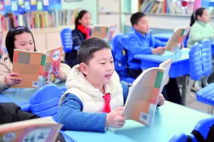     热爱阅读的黄有之（中），目前背诵的诗词量已达600多首。邹乐 摄