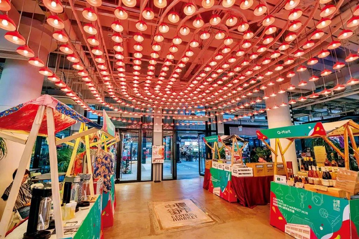 ● 街市的底层入口处吊挂着巨大的红色胶灯灯罩装置，红灯罩是香港传统街市的象征，过去的小贩常用红色胶灯的暖光提升产品卖相。