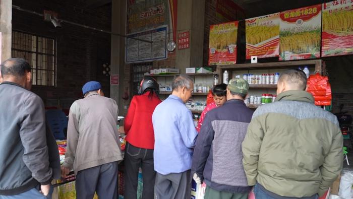   村民在广西樟木镇的农业技术咨询服务部里购买稻种。（视频截图）