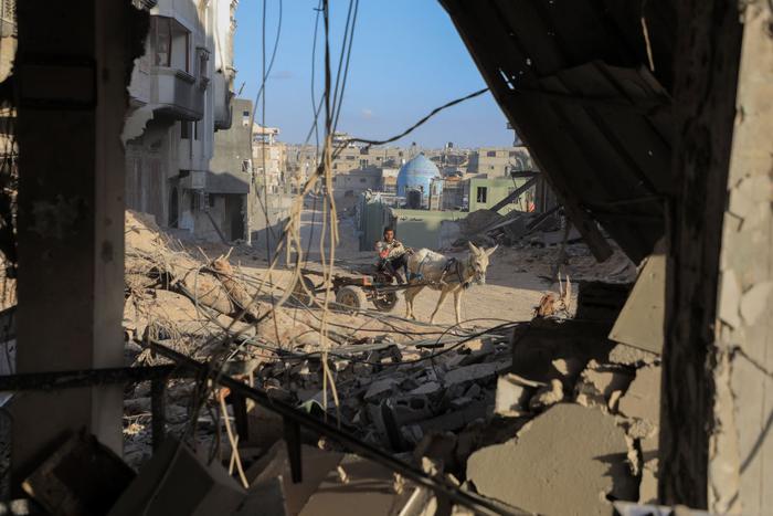 3月6日，在加沙地带南部城市汗尤尼斯，一名男子经过建筑废墟。新华社发（里泽克·阿卜杜勒贾瓦德摄）