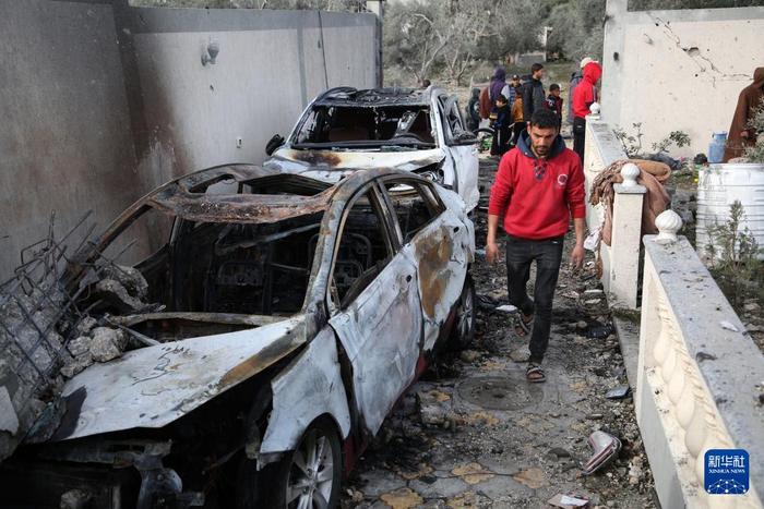 3月26日，在加沙地带南部城市拉法，一名男子走过被以军炸毁的车辆。新华社发（哈立德·奥马尔摄）
