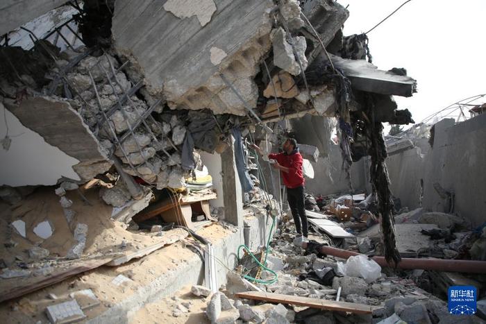 3月26日，在加沙地带南部城市拉法，一名男子查看以军空袭后的废墟。新华社发（哈立德·奥马尔摄）