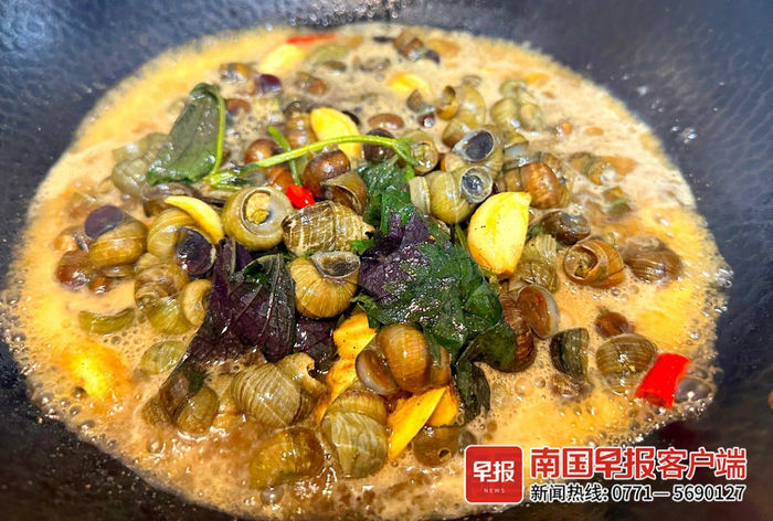 ▲香喷喷炒螺餐。记者 何定坚 摄