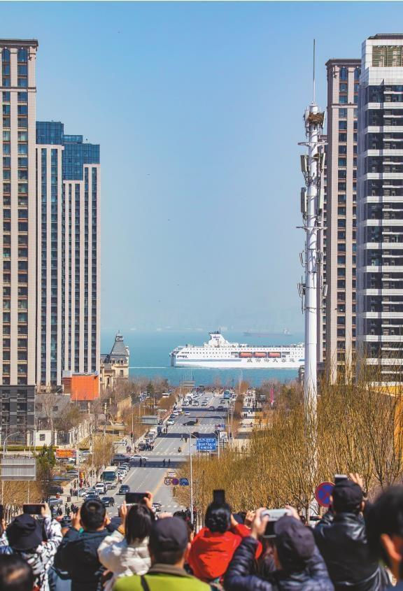         人们纷纷按下快门，记录客滚船从楼宇间驶过的时刻。 李  帅  摄