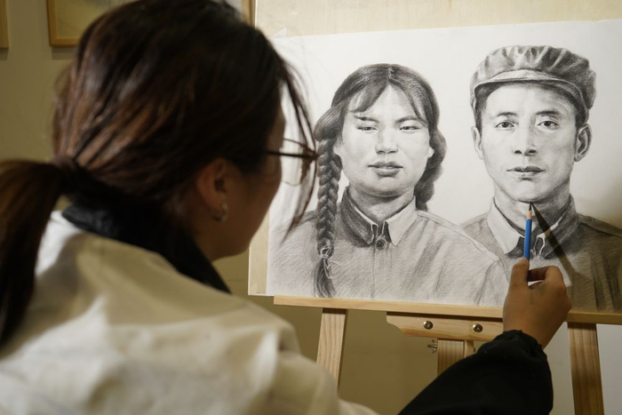 安徽师范大学的"00后"大学生俞家瑞用手机拍摄自己创作的烈士画像