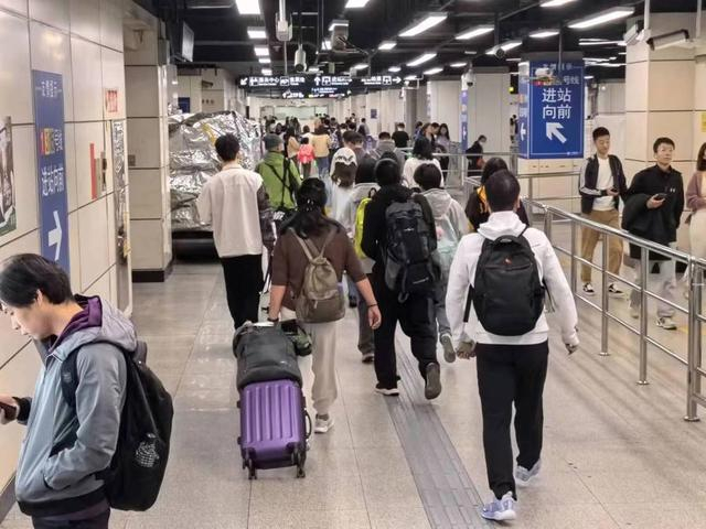 △免除重复安检带来的方便和效率提升显而易见。图为铁路出站的乘客正从4号出入口口进入地铁站。