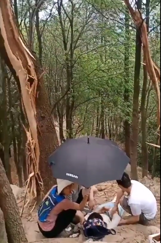 有人为被雷击的女子撑伞。网络图