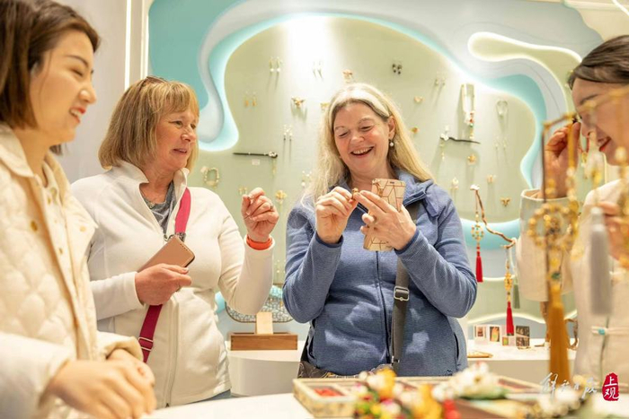 海外游客在商铺试戴首饰，笑逐颜开。  孟雨涵 摄