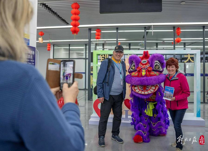 邮轮游客与舞狮表演者合影。  孟雨涵 摄