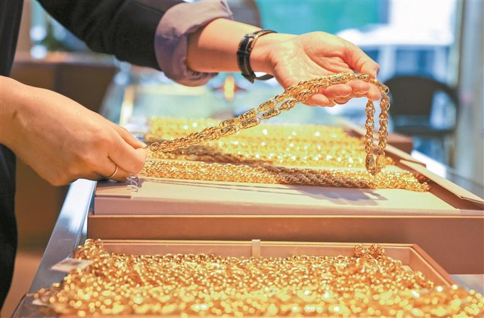  顾客在一家金店挑选黄金首饰。新华