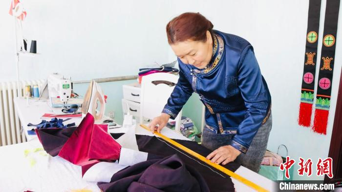 图为斯琴正在裁布。茫崖市委宣传部 供图