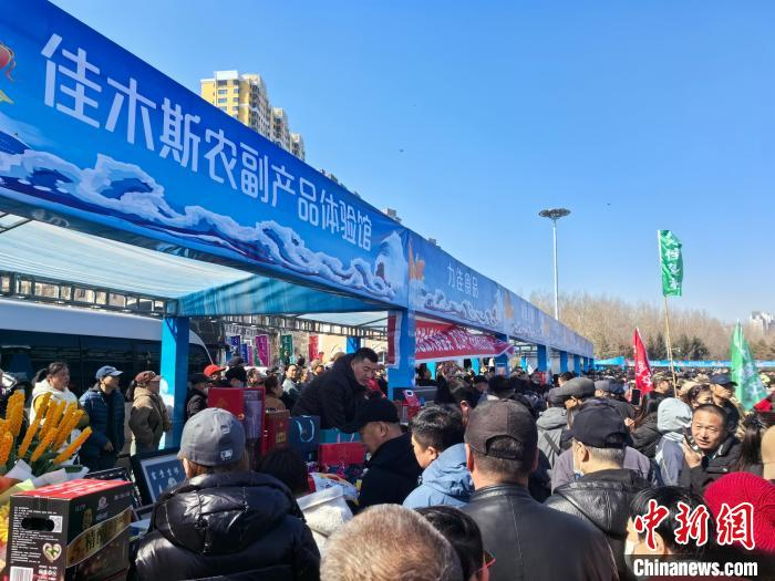 游客和佳木斯市民在活动现场品尝、购买农副产品。姜辉 摄