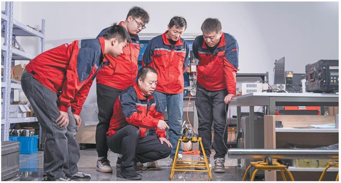 严正国（中）和团队成员在工作现场。 受访者供图