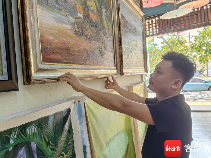昌飞在画廊整理油画作品。记者 任桐 摄