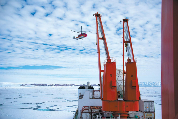 KA-32直升机在“雪龙”号吊运考察物资。本报特派记者 王少勇 摄