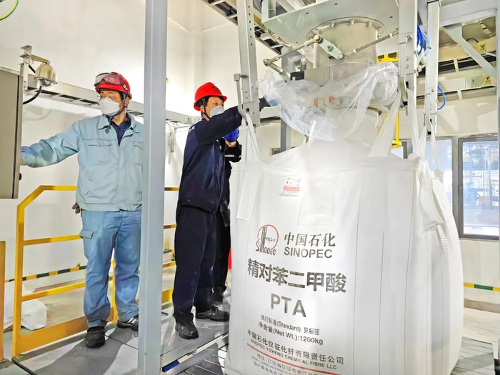 仪征化纤PTA部员工正在打包第1包PTA产品。&nbsp;摄影：刘玉福