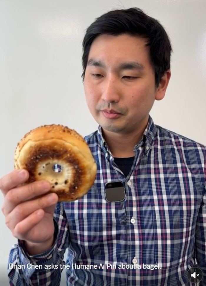 （Brian Chen拿着百吉饼询问AI Pin，来源：纽约时报）