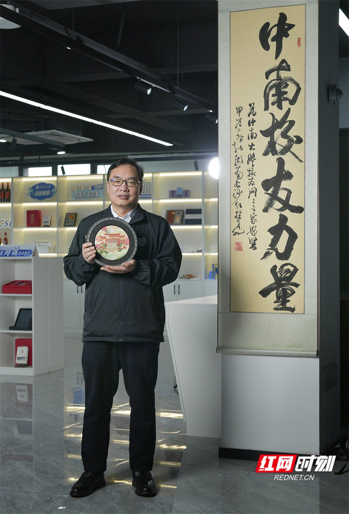 谢向东手上拿着中南大学文创产品.